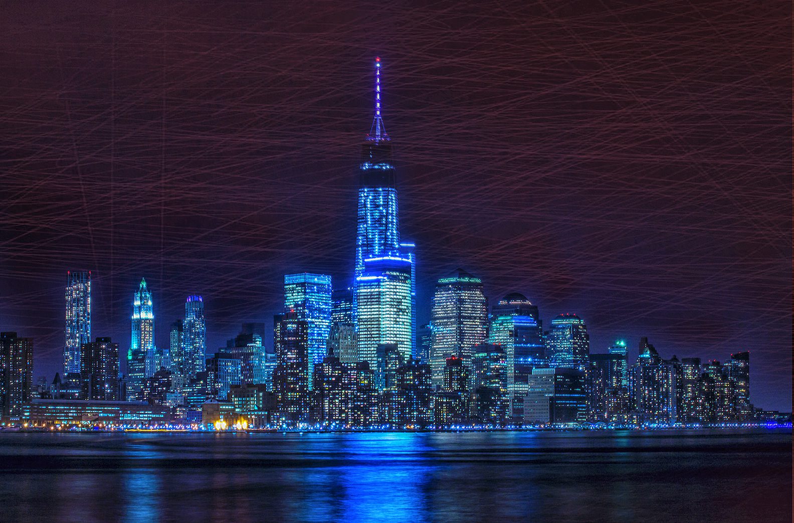 A city skyline with the lights on at night.