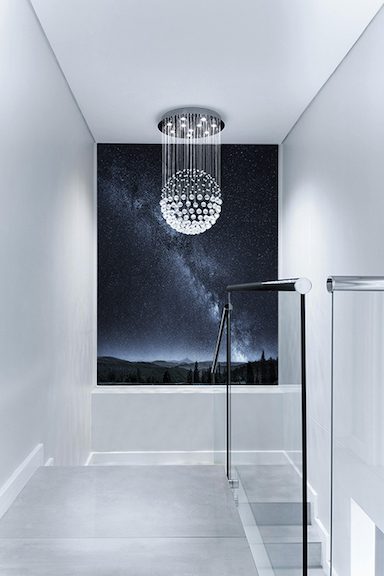 A bathroom with a large mirror and a chandelier